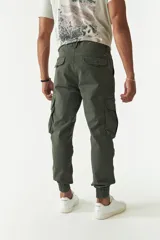 Pantalón cargo gris con puños elásticos, corte regular, bolsillos laterales con solapa y pasacintos.