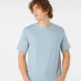 Remera celeste de corte recto, manga corta y cuello redondo. Tiene un bolsillo pequeño en el pecho.
