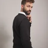 Buzo negro de punto con tejido trenzado en la parte frontal, de corte clásico.