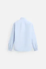 Camisa celeste de algodón, corte relaxed fit, cuello abotonado, manga larga con puños abotonados y cierre frontal con botones.