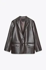 Blazer marrón oscuro de efecto piel, con cuello solapa y manga larga. Tiene bolsillos de plastrón en la parte delantera, forro interior a tono y cierre frontal con botones.