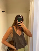 Musculosa marrón de tejido de punto con brillo, escote en V y espalda descubierta.