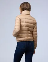 Campera puffer reversible Michael Kors color rosa con estampado de logos MK en un lado y liso en el otro. Tiene cierre central metálico, bolsillos delanteros y avíos metálicos con logo. Incluye bolsa autoportante.