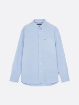 Camisa celeste de corte amplio confeccionada en sarga de puro algodón teñido en prenda, con cuello abotonado, bolsillo de parche en el pecho, puños redondeados con botón y logo de Tommy Hilfiger bordado en el bolsillo del pecho.