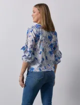 Blusa de gasa blanca, marca Sioni, con mangas 3/4 y aplique de volados.