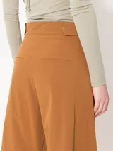 Pantalón color marrón confeccionado en poplin 4way. Incluye bolsillos laterales y ojales en la parte trasera, con presillas en la cintura para ajuste. Acceso mediante cierre, gancho pantalonero y botón interno.