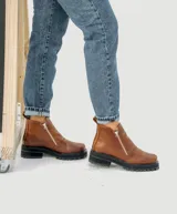 Bota de cuero vacuno color marrón, con interior forrado en corderito natural. Tiene suela de goma artesanal, punta cuadrada, cierre YKK en ambos lados y caña de 11cm.