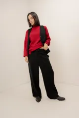 Pantalón sastrero color beige, de corte recto y tiro alto, con bolsillos laterales y cierre frontal con botón y cremallera.