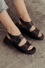 Sandalias color beige con tiras de cuero y ajuste con velcro, con base chunky negra.