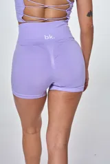Conjunto deportivo lila compuesto por un top de tirantes con logo 'bk.' y un short de tiro alto. El top es de corte ajustado y tiene textura acanalada. El short es de corte ajustado y tiene cintura alta.