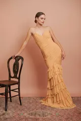 Vestido largo color durazno, entallado, con escote en V, breteles finos, drapeado en el frente y falda con volados.