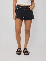 Short de jean negro con roturas y terminaciones desflecadas.