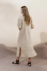 Vestido largo rojo con escote en V, mangas abullonadas con elástico en el puño y detalle de pespunte en contraste. Presenta un canesú con efecto punto smock y bolsillos laterales.