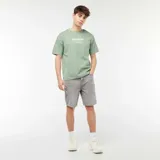 Camiseta verde con estampado rectangular en el pecho con texto en blanco.