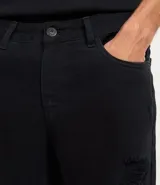 Bermuda masculina de sarga blanca, modelo slim, con rotos (destroyed) en la parte delantera de ambas piernas. Presenta cintura fija con trabillas, cierre de botón y cremallera, y bolsillos.