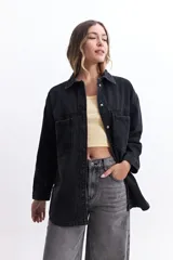 Campera de jean celeste de corte holgado, con cuello camisero, cierre frontal con botones metálicos, mangas largas con puños abotonados, bolsillos frontales con solapa y costuras a la vista.
