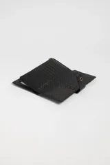 Billetera larga negra con textura tejida y cierre con broche dorado.
