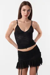 Minifalda negra de microtul con cintura ancha fruncida y tiras ajustables.