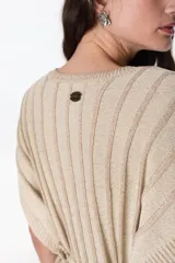 Vestido corto de tejido de punto con cuello V y mangas cortas, con diseño de rayas verticales en tonos azul oscuro y negro, con hilos de lurex que le dan brillo. Se ajusta a la cintura con un lazo fino negro.