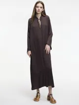 Vestido largo color crema, con cuello mao con lazo ajustable, mangas largas amplias y tajos laterales.
