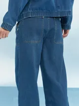 Pantalón de jean celeste de corte ancho con paneles y costuras a la vista.