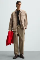 Pantalón verde militar de corte carrot fit, confeccionado en tejido de algodón. Cuenta con cintura elástica ajustable con cordón, bolsillos frontales y un bolsillo trasero de plastrón.