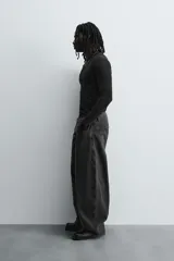 Camiseta de manga larga color crudo, corte ajustado y cuello redondo. Tiene aberturas en los puños y efecto lavado.