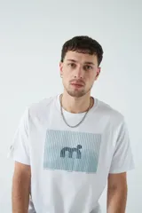 Remera color marrón con estampado rectangular con líneas horizontales y figura geométrica en el centro.