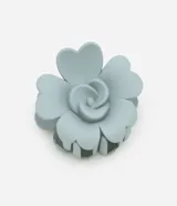 Pinza para el pelo de plástico gomoso color celeste, con forma de flor.
