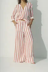 Pantalón blanco de lino, de corte palazzo y cintura con cordón ajustable.