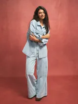 Pantalón de jean celeste de corte acampanado con costuras verticales en el frente.