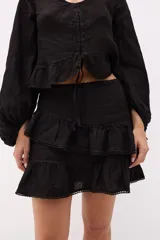 Minifalda marrón con volados superpuestos y terminaciones deshilachadas.