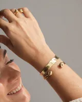 Brazalete rígido abierto de bronce con forma de herradura.