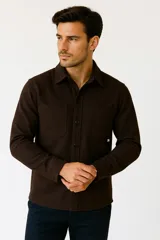 Camisa marrón de poliéster con cuello solapa, manga larga, cierre frontal con botones y dos bolsillos de parche en el pecho.