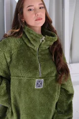 Buzo verde de peluche corderito con cierre parcial en el cuello y logo cuadrado en el pecho.