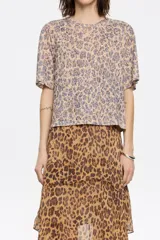 Remera de poliéster y algodón con estampado animal print de leopardo, corte recto, escote redondo y mangas cortas.
