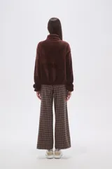 Buzo de polar tipo sherpa en color crudo, con cuello alto y cierre frontal parcial. Presenta un bolsillo de parche con cierre en el pecho y mangas largas de calce holgado.