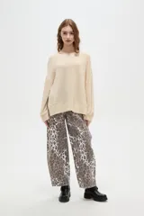 Sweater holgado de poliéster y lurex, color beige, con cuello redondo y manga larga.