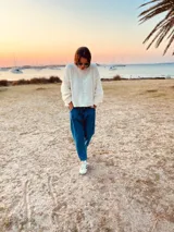 Sweater tejido en boucle color crema, de corte holgado y mangas largas.