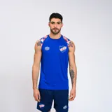 Musculosa deportiva azul con cuello y sisas en blanco. Presenta el escudo del Club Nacional de Football y el logo de Umbro en el pecho. Diseño con estampado de camuflaje en hombros y laterales.