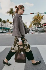 Bolso de hombro tipo shopper de cuero sintético color marrón oscuro, con pespuntes decorativos en el cuerpo y asas delgadas. Cierre principal con botón imantado y bolsillo interior con cremallera.