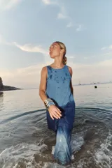 Vestido corto de denim celeste, con escote redondo, espalda descubierta y logo bordado en el frente.