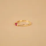 Anillo de oro amarillo 9k con un rubí central de forma ovalada y circonias engarzadas en los laterales.