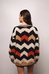 Buzo tejido a mano con lana merino, estilo oversized con diseño de ondas en colores blanco, negro, azul y marrón.