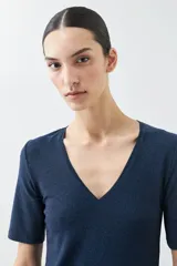 Remera color beige de lurex con escote en V y mangas cortas.
