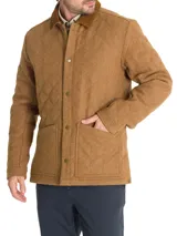 Chaqueta acolchada gris con patrón de rombos, cuello de pana marrón, cierre con broches metálicos, bolsillos frontales y bolsillo interno.