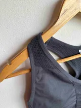 Top deportivo gris con espalda racerback y paneles de malla.