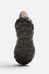 Zapatilla botín color gris, con combinación de piezas de piel y otros materiales en el corte. Cordonera con siete pasados y suela con volumen y diseño de textura.