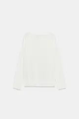 Jersey de punto liso, color azul brillante, con cuello redondo y manga larga. Presenta acabados en rib en puños, cuello y bajo, con aberturas laterales en el ruedo.