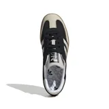 Championes Adidas Samba OG, color negro con detalles en blanco y suela de goma marrón. Inspirados en el modelo icónico de fútbol sala de los años 50, con parte superior de cuero suave, punta reforzada y las emblemáticas 3 Tiras.